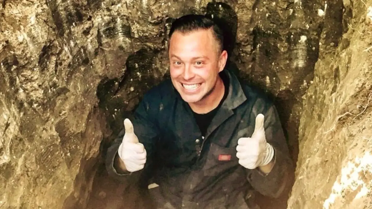 Mark Ellefson giving a thumbs up from a sewer trench